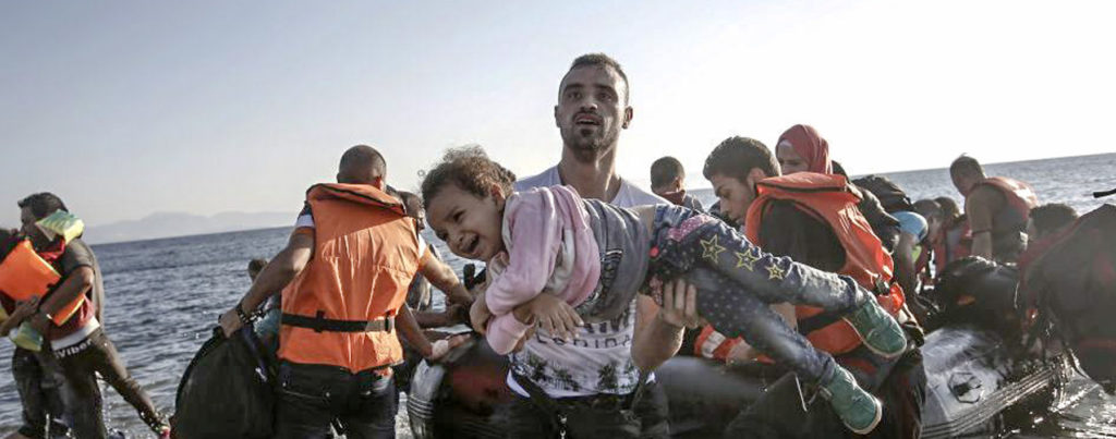 A Syrian migrant holds a young girl in his arms upon arriving on a dinghy to the Greek island of Kos, Greece.(EPA/Yannis Kolesidis)