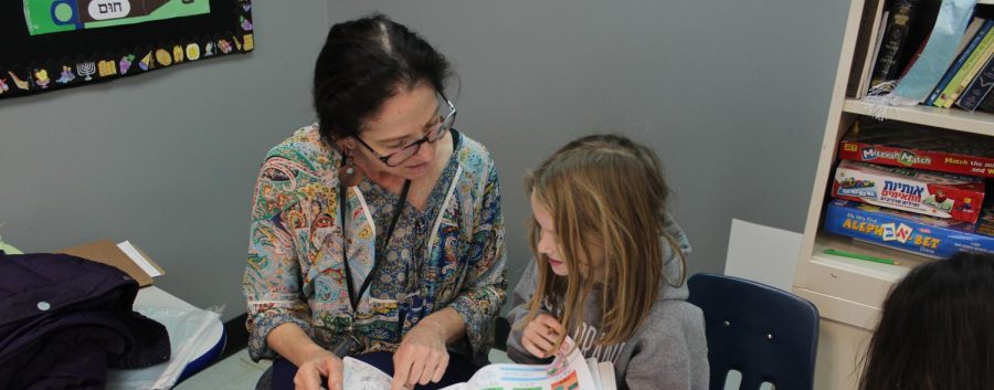 Rieber helping a student with their Hebrew workbook. Image by Molly Soloman.