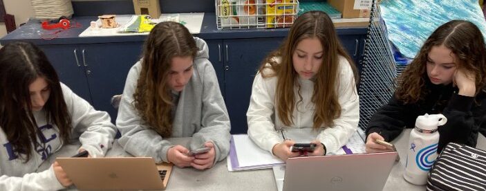 Students distracted by their devices. Photo by Denah Thomas.