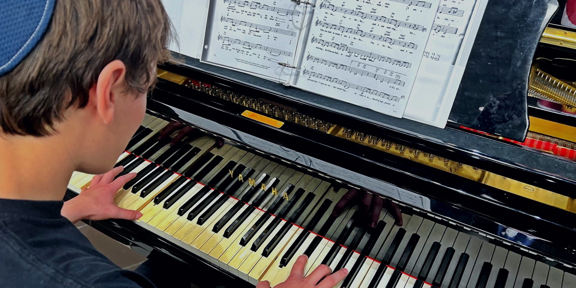 Student Noah Bergh plays the popular Jewish folk song, “I am a Latke.” Photo by Simon Balanoff.