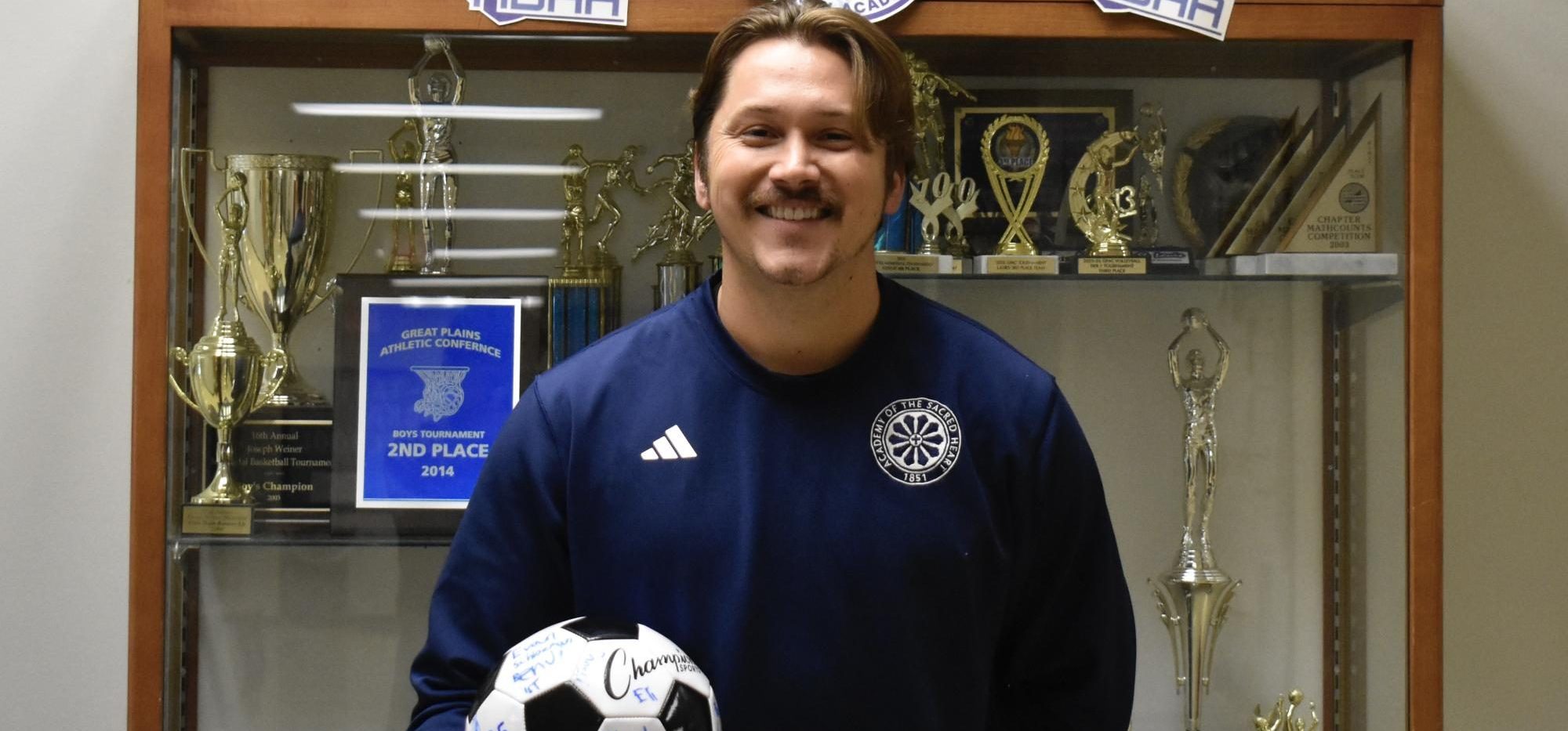 Ness is holding a soccer ball that HBHA students and faculty signed as a welcoming gift when he first came to HBHA. Photo by Rhys Pabst.