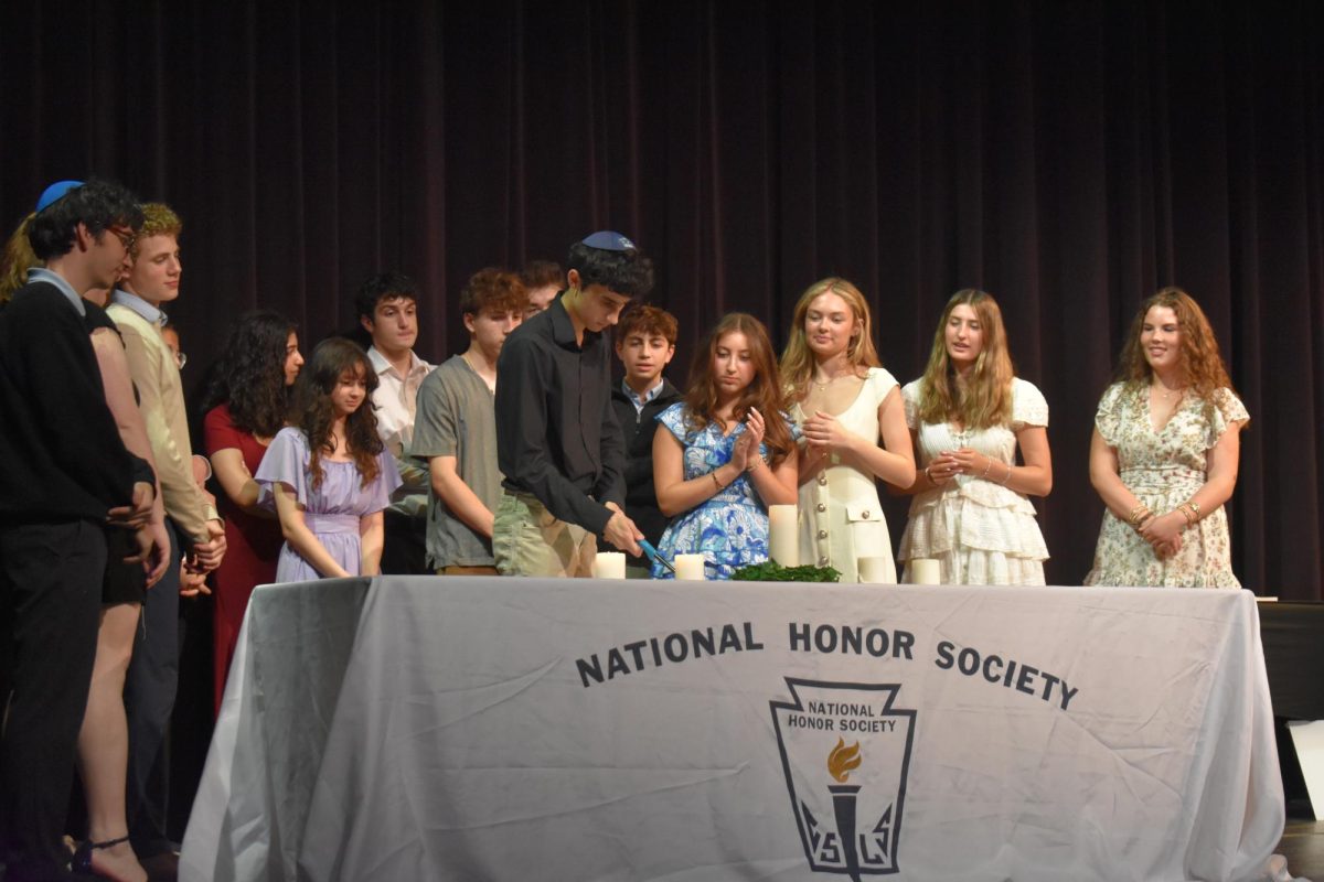 Uriel Noorollah, sophomore, lights the candle as part of the induction ceremony to the National Honors Society. The Honors Assembly was an opportunity to honor all of our Upper-School students' accomplishments. 
Photo by Jaxson Rosenberg