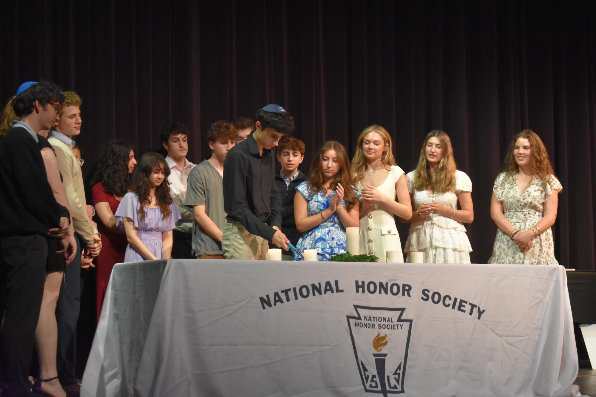 Uriel Noorollah, sophomore, lights the candle as part of the induction ceremony to the National Honors Society. The Honors Assembly was an opportunity to honor all of our Upper-School students' accomplishments. 
Photo by Jaxson Rosenberg